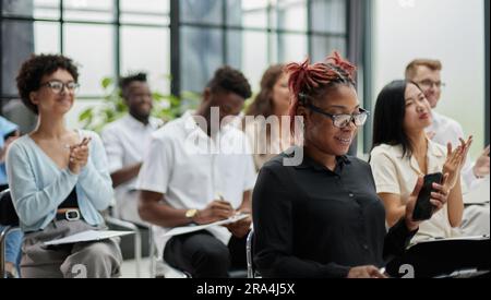 Selective focus of attractive business people sitting on chairs and talking in conference room Stock Photo