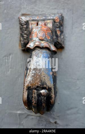 A black weathered lucky hand door knocker Stock Photo