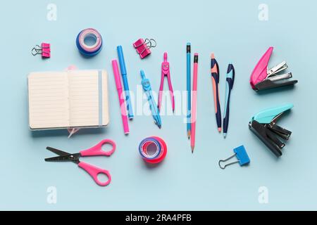 Composition with blank notebook and stationery supplies on blue background Stock Photo