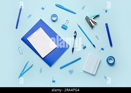 Composition with blank notebook and stationery supplies on blue background Stock Photo