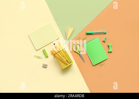 Composition with notebooks and different school stationery on color background Stock Photo