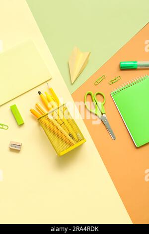 Composition with notebooks and different school stationery on color background Stock Photo