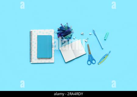Composition with notebooks and different school stationery on blue background Stock Photo