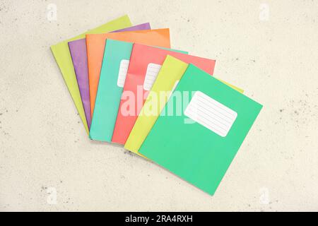 Different colorful notebooks on grunge light background Stock Photo