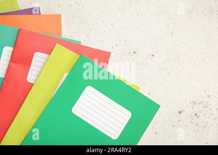 Different colorful notebooks on grunge light background Stock Photo