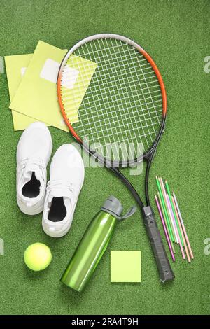 Sneakers with bottle of water, tennis ball, racket and different stationery on color background Stock Photo