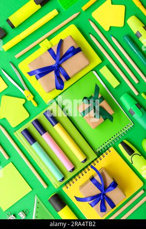 Gift boxes with different stationery on green background Stock Photo
