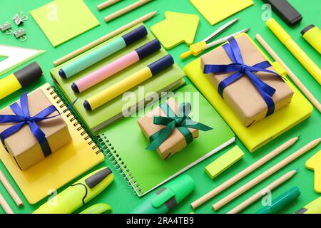 Gift boxes with different stationery on green background Stock Photo