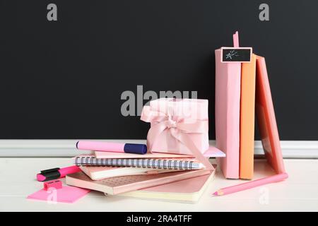 Gift box with different stationery on white wooden table in classroom Stock Photo