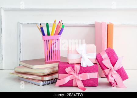 Gift boxes with books and different stationery on white table Stock Photo