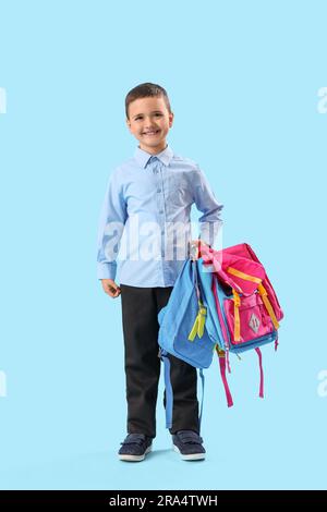 Little schoolboy with backpacks on light blue background, back view ...