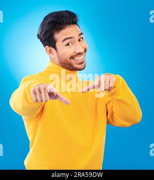Man, studio portrait and point at you with smile, choice and recruitment with fashion by blue background. Young Indian guy, gen z student and finger Stock Photo