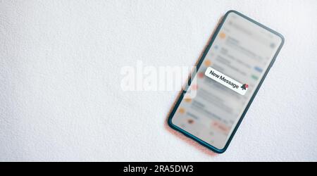 Banner of a smartphone with a new message notification on screen and white texture background. Communication business technology. Inbox view. Stock Photo