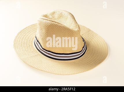 Large sun hat made of light straw for holidays on a light background. Stock Photo