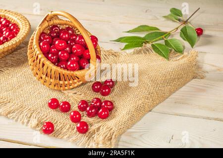Small basket full of cherries on a burlap napkin.Rustic style Stock Photo