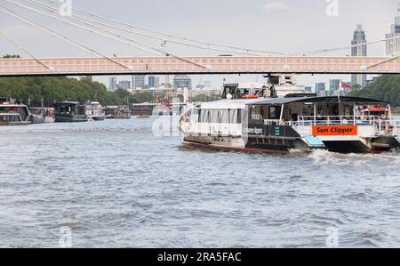 Closeup of a Thames Clipper Uber Boat passing under Rowland Mason Ordish's Albert Bridge in Chelsea, London, England, U.K. Stock Photo