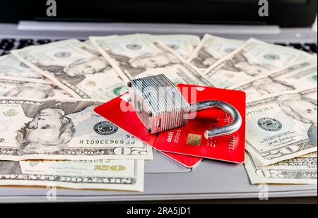 Close up of Padlock on top of credit card on dollar bills, Concept of credit card information theft. Padlock with credit card on top of dollars Stock Photo