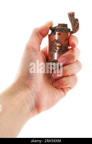 Female hand holds old bronze gas lighter isolated on a white background Stock Photo