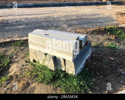 concrete blocks lie on brown soil and lawn. concrete is used for the construction of a nuclear sarcophagus. safety of people from radiation. concrete Stock Photo