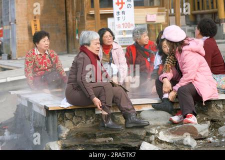 Japanese women bathing feet in hot spring, Lake Kussharo, Hokkaido, Japan Stock Photo