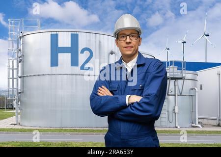 Engineer in helmet on a background of Hydrogen factory. Stock Photo