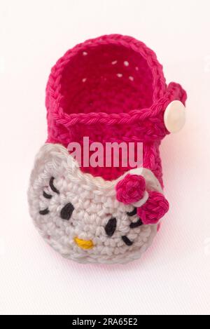 shoes with faces for a newborn, crocheted, on a white background Stock Photo