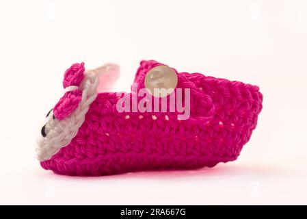 shoes with faces for a newborn, crocheted, on a white background Stock Photo