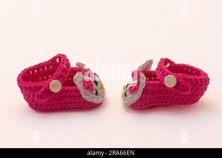 shoes with faces for a newborn, crocheted, on a white background Stock Photo