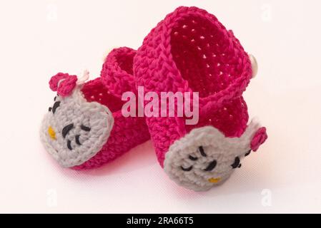 shoes with faces for a newborn, crocheted, on a white background Stock Photo