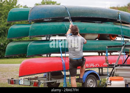 Ditfurt, Germany. 01st July, 2023. Canoes lie on a boat trailer. A boat rental offers water recreation on the Bode. Visitors can experience the Bode and the Bode floodplain on a long section from the waterway and make acquaintance with the diverse flora and fauna along this river. The tours can last from three to six hours. Credit: Matthias Bein/dpa/ZB/dpa/Alamy Live News Stock Photo