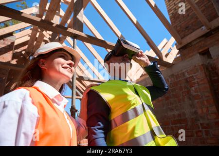Building engineers walking at construction site in virtual reality headset Stock Photo