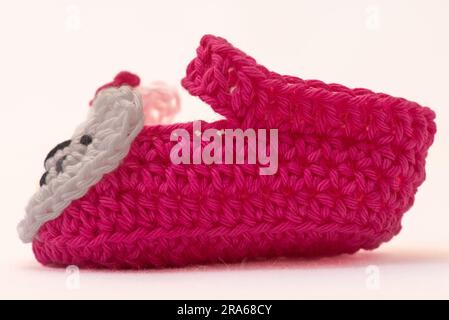 shoes with faces for a newborn, crocheted, on a white background Stock Photo