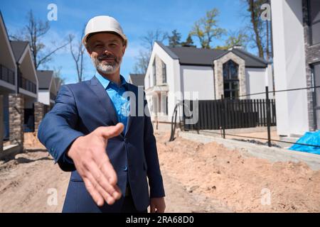 Smiling businessman dealing with contractors, giving hand for handshake Stock Photo
