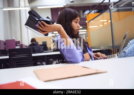 Female employee doing work tasks in modern room Stock Photo