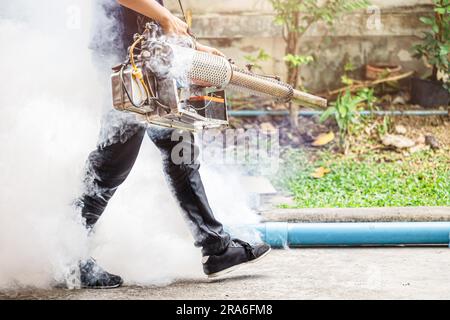 pest control staff spray chemical smoke eliminate mosquito larvae rats cockroach bugs around office building outdoor. Stock Photo