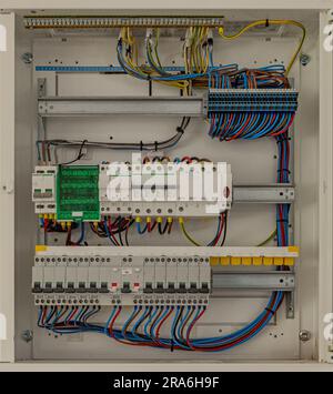 Electrical panel with multi-colored wires. Voltage distributor with circuit breakers. Stock Photo