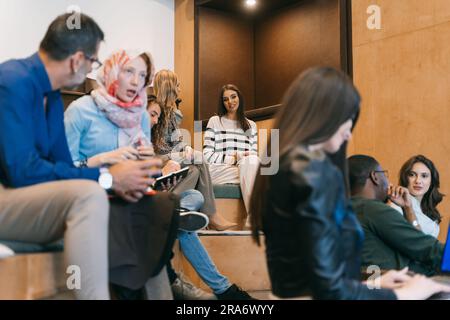 Diverse group of employees working together. Two women discussing something at work Stock Photo