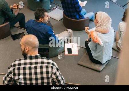 Talk if you have problems at work! Two different aged, multicultural colleagues discussing at work Stock Photo