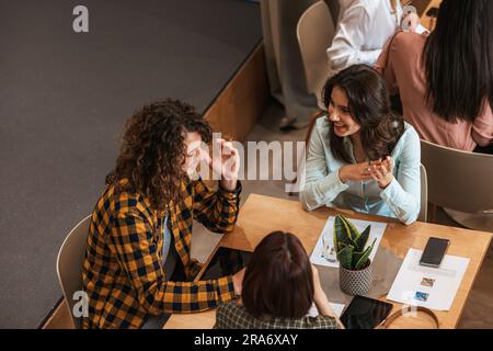 Friends working together and talking at the cafe Stock Photo