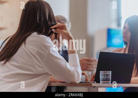Brunette female employee learning new business tricks while working with her experienced 70s company leader. Back view photo Stock Photo
