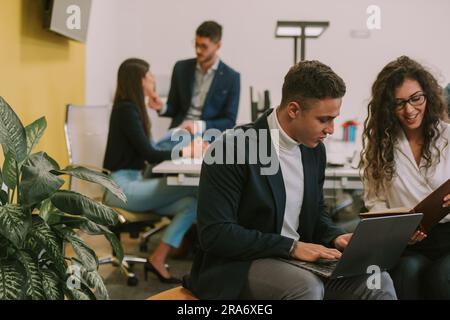 Close up of two business colleagues working together while looking at the notes and talking Stock Photo