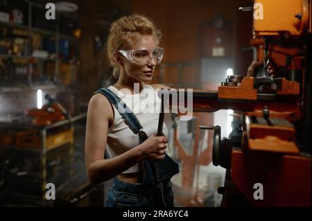 Woman wearing safety protective goggles working on milling and drilling machine Stock Photo