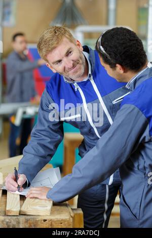 carpenter with apprentice in training period Stock Photo