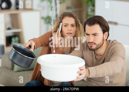upset couple calling insurance for home leaks Stock Photo