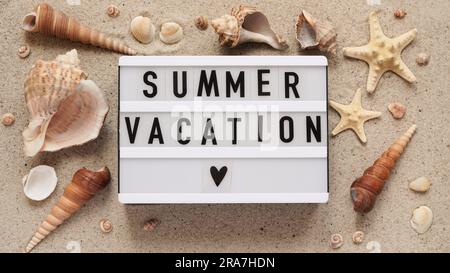 Beach summer vacation banner concept.Text board with the inscription SUMMER VACATION, seashells and starfish lie on the sand, top view, flat lay, copy Stock Photo