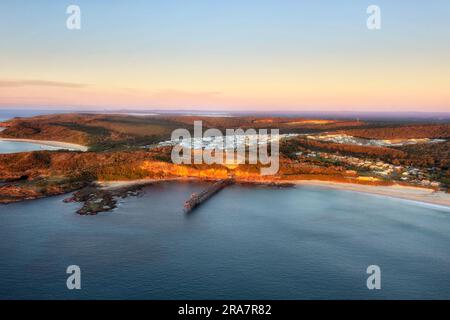Middle Camp beach at Catherine Hill bay town on Australian Pacific coast with historic jetty - sunrise aerial landscape. Stock Photo