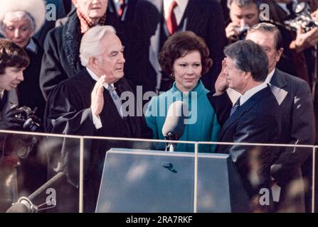 Jimmy Carter is sworn in as 39th President of the United States by Supreme Court Chief Justice Warren Burger. By Carter's side is his wife, Rosalynn and Vice President Walter Mondale. Photograph by Bernard Gotfryd Stock Photo