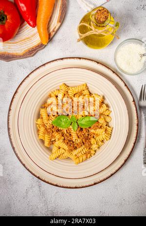 Fusilli pasta with minced meat, tomato sauce, cheese and basil Stock Photo