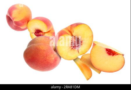 Cut and whole fresh ripe peaches falling on white background Stock Photo