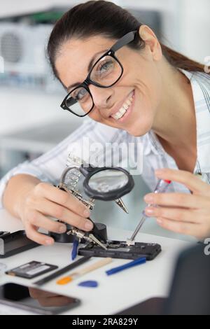 engineer woman repairs laptop support fixing notebook computer Stock Photo